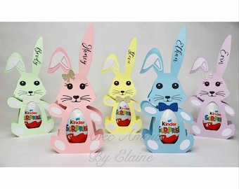 Könnte beinhalten: Fünf pastellfarbene, bunnyförmige Pappkartons mit personalisierten Namen: Brody, Honey, Steve, Ethan und Erin. Jede Box enthält ein rotes und gelbes Kinder Überraschungsei.
