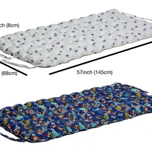May include: Two floor cushions with different patterns. The first cushion is white with gray stars and measures 26.8 inches by 57 inches. The second cushion is blue with a jungle print and measures 26.8 inches by 57 inches.