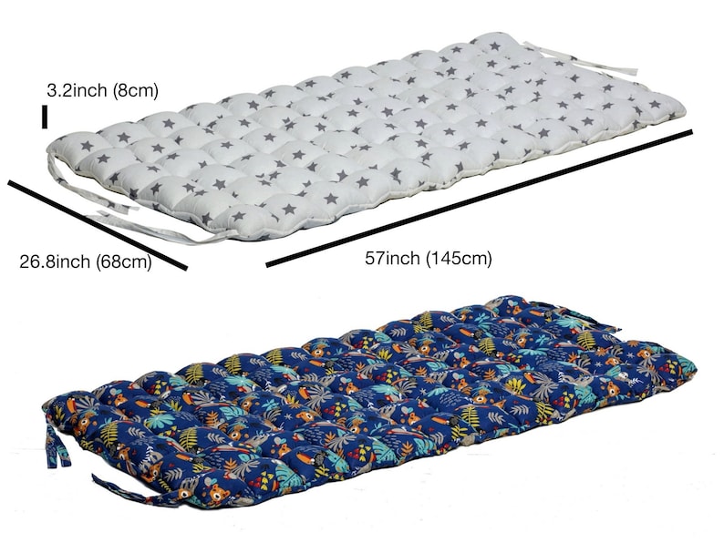May include: Two floor cushions with different patterns. The first cushion is white with gray stars and measures 26.8 inches by 57 inches. The second cushion is blue with a jungle print and measures 26.8 inches by 57 inches.