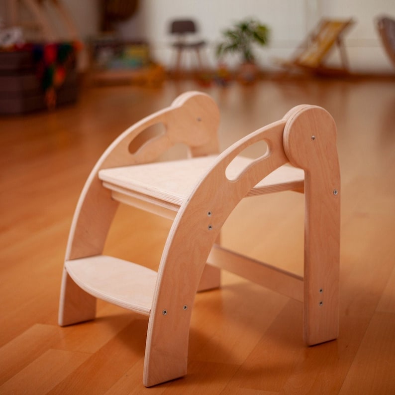 May include: A light wood step stool with rounded edges and two steps. The stool has a smooth, natural finish and is designed for children.