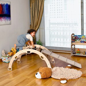 Montessori-inspired wooden rocker with slider and ladder ramps for kids.