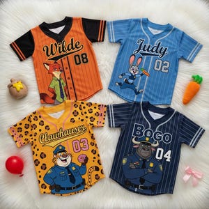 Puede incluir: Cuatro camisetas de b&eacute;isbol con personajes de Zootopia. Las camisetas son naranja, azul, amarilla y azul marino, cada una con el nombre y el n&uacute;mero de un personaje. La camiseta naranja tiene "Wilde" y "08", la azul tiene "Judy" y "02", la amarilla tiene "Clawhauser" y "03", y la azul marino tiene "Bogo" y "04".