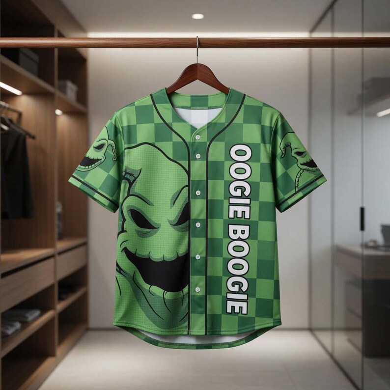 May include: Green baseball jersey featuring a checkered pattern and the face of Oogie Boogie from The Nightmare Before Christmas. The jersey has the text "OOGIE BOOGIE" down the side and is hanging on a wooden hanger.