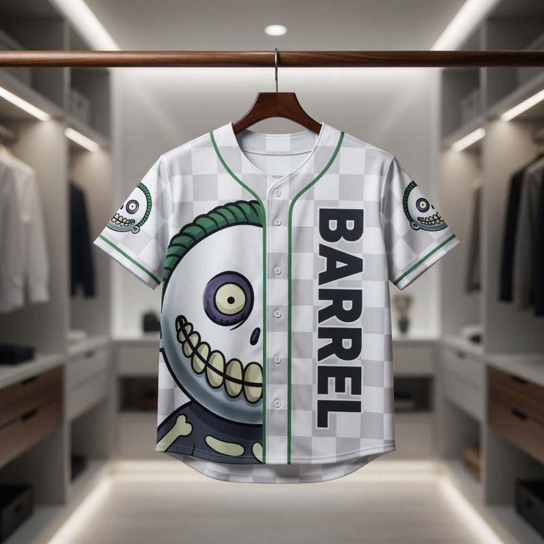 May include: White and gray baseball jersey with a checkerboard pattern and green trim. The jersey features a large cartoon skull graphic on the front and the word "BARREL" printed vertically. The sleeves have a small skull graphic.