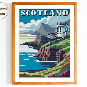 May include: Cross stitch pattern of a colourful landscape with a castle in Scotland. The pattern features a blue sky, green hills, a blue body of water, and a white castle with red roofs. The text "Scotland" is printed in white letters on a blue background.