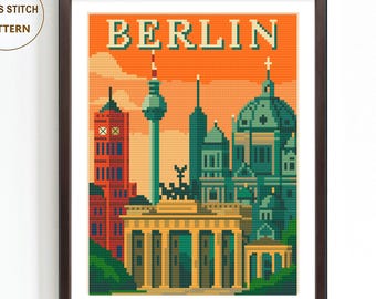 May include: A framed cross stitch pattern featuring a pixelated illustration of Berlin landmarks. The artwork includes the Brandenburg Gate, the Berlin TV Tower, and the Berlin Cathedral, set against an orange sky. The word "BERLIN" is displayed at the top.