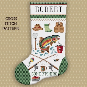 May include: A white Christmas stocking featuring a cross stitch pattern with the name ROBERT at the top. The design includes a colorful trout, fishing rods, a hat, boots, a vest, a net, a bucket, a mug, and a tackle box with the text GONE FISHING.