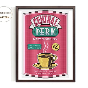 May include: Framed cross-stitch art depicting the Central Perk logo from the TV show Friends. The design includes a coffee cup, the text "New York, NY," and the phrase "The place where friends meet."