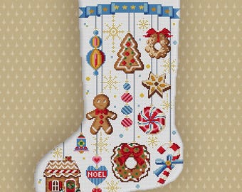 Könnte beinhalten: Ein weißer Weihnachtsstrumpf mit dem Namen "THOMAS" oben aufgestickt. Der Strumpf ist mit Kreuzstichmotiven zum Thema Weihnachten verziert, darunter ein Lebkuchenmann, eine Zuckerstange und ein Lebkuchenhaus.