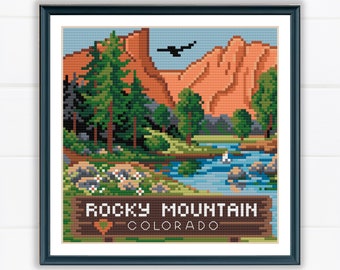 Może przedstawiać: Wzór na haft krzyżykowy przedstawiający malowniczy krajobraz z górami, drzewami, rzeką i tabliczką z napisem "Rocky Mountain Colorado".