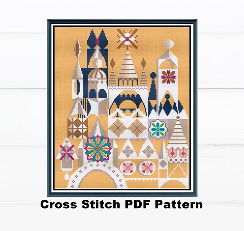 May include: A framed cross-stitch pattern featuring a whimsical architectural design in shades of gold, blue, white, and pink. The pattern includes geometric shapes and floral accents. The text "Cross Stitch PDF Pattern" is at the bottom.