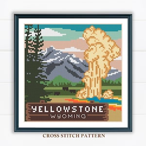 Puede incluir: Patrón de punto de cruz de un paisaje colorido con un géiser en erupción en primer plano. El letrero dice "Yellowstone Wyoming".