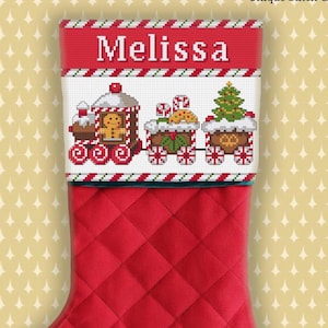 May include: Red Christmas stocking with a quilted pattern. The top features a cross-stitched design of a train with gingerbread men, candy canes, and a Christmas tree. The name "Melissa" is stitched in white.