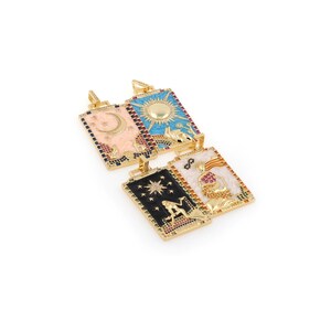 May include: Four gold-toned pendants with colorful enamel and rhinestones. Each pendant features a different tarot card design: The Moon, The Sun, The Star, and The Lovers.