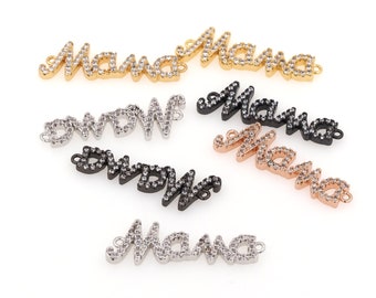 Puede incluir: Seis dijes de metal de diferentes colores con la palabra "Mama" escrita en pedrería. Los dijes son de oro, plata, oro rosa y negro.
