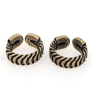 Peut inclure: Deux bagues dorées avec un design tressé. Les bagues sont ouvertes et peuvent être ajustées pour s'adapter à différentes tailles de doigts.