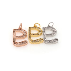 May include: Three letter 'E' charms, each with a different metal finish: rose gold, gold, and silver. Each charm is encrusted with clear cubic zirconia stones.