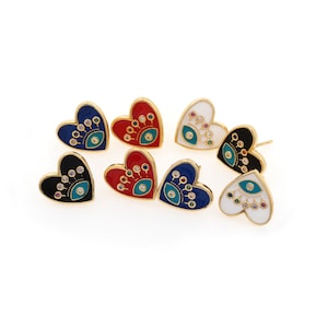 May include: Six pairs of heart-shaped earrings featuring an evil eye design. The earrings are made from gold metal and have a colourful enamel finish. The evil eyes are decorated with colourful rhinestones.