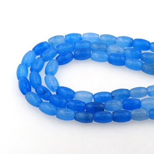 Puede incluir: Una hebra de cuentas de piedra preciosa ovaladas de color azul claro. Las cuentas son lisas y pulidas, y tienen una apariencia translúcida.