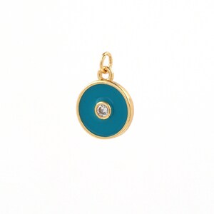 May include: Gold charm with a blue enamel circle and a small clear rhinestone in the center. The charm is designed to resemble a protective eye.
