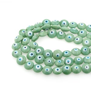 Op de afbeelding: Een streng groene glazen kralen met blauwe en witte boze oog bedels.