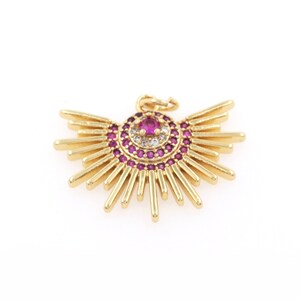 Può includere: Ciondolo pendente in oro con un design a raggiera di cristalli rosa e bianchi. Il ciondolo presenta un cristallo rosa centrale circondato da cristalli bianchi più piccoli.