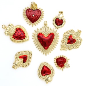 May include: Assortment of eight red and gold heart-shaped charms with intricate details. The charms feature a variety of designs, including a crown, a cross, and a heart with an eye.