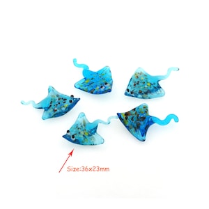 Puede incluir: Cinco figuritas de raya azul de vidrio con motas blancas y doradas. Las rayas miden aproximadamente 36 mm por 23 mm.