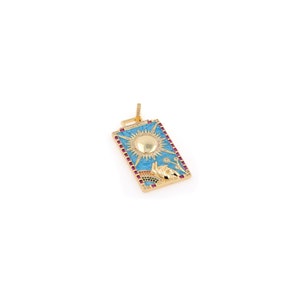 May include: Gold pendant with a blue enamel rectangle featuring a sun with a gold center and a hand reaching up. The pendant is decorated with small red and green gemstones.