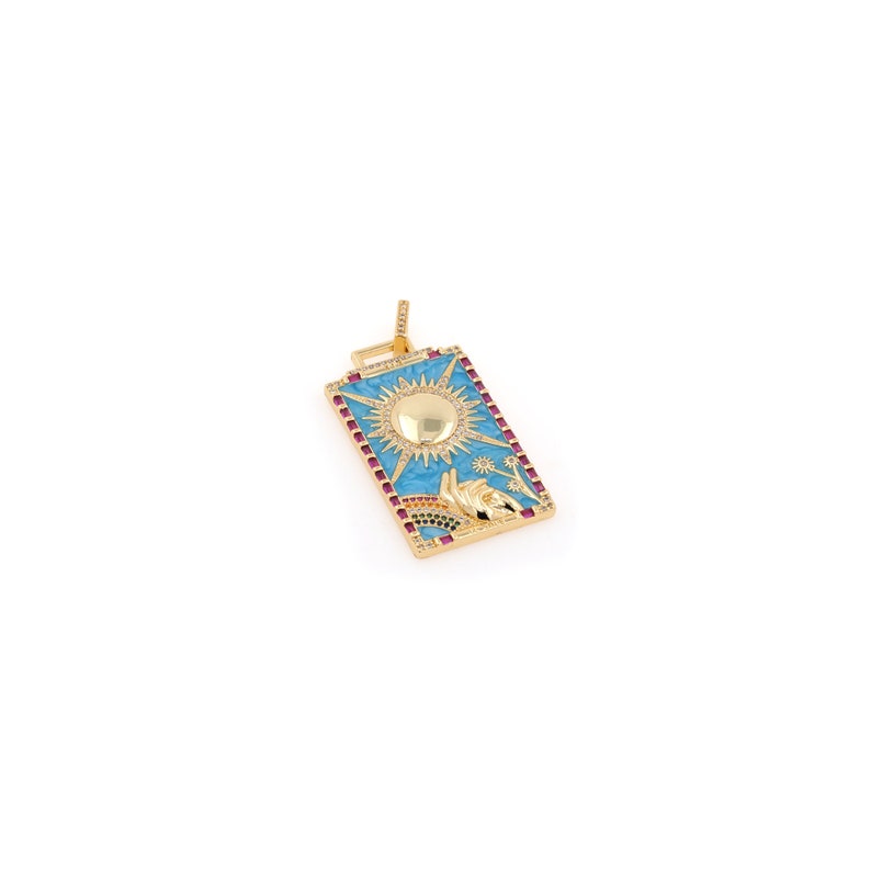 May include: Gold pendant with a blue enamel rectangle featuring a sun with a gold center and a hand reaching up. The pendant is decorated with small red and green gemstones.