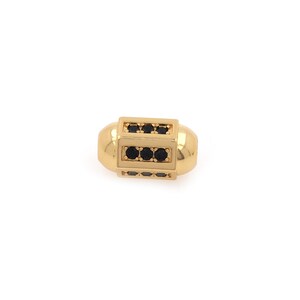 May include: Gold-toned bead with black cubic zirconia stones set in a rectangular frame.
