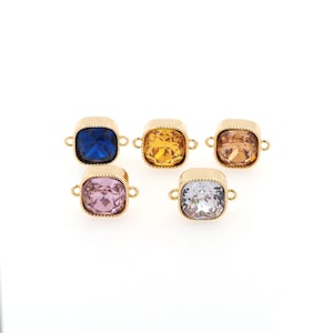 May include: Five gold-toned connector charms with square-shaped crystal accents. The crystals are in shades of blue, yellow, pink, and clear.