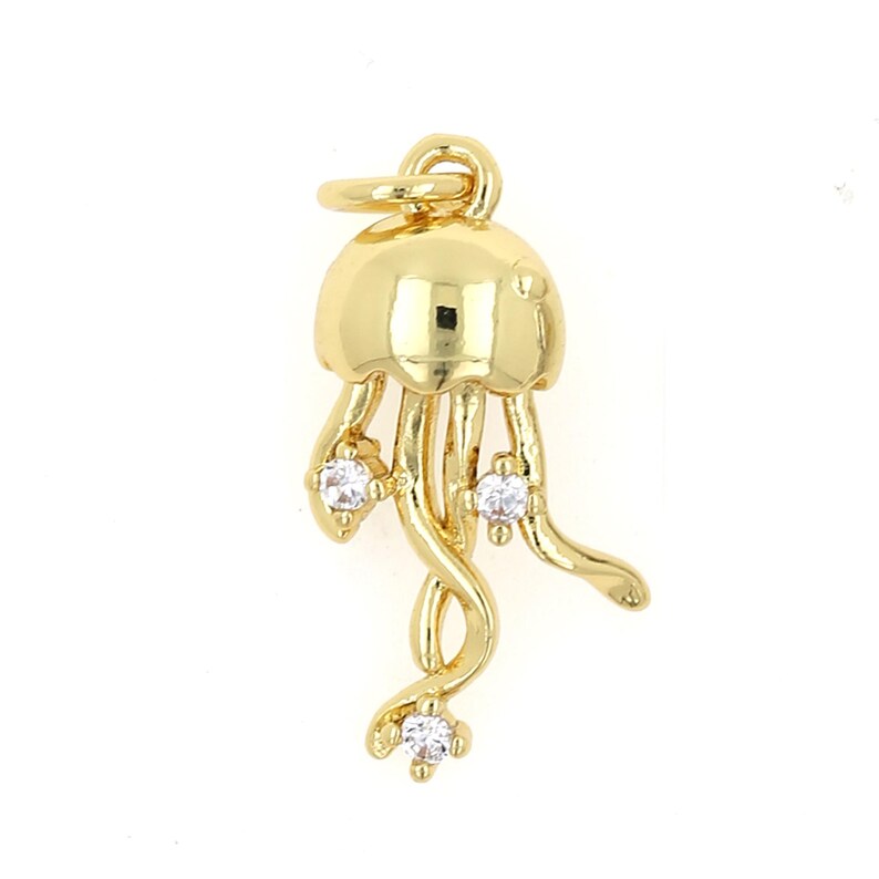 May include: Gold-toned charm shaped like a jellyfish with clear crystal accents.