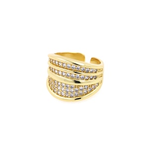 Puede incluir: Un anillo de oro con una banda ancha adornada con varias filas de piedras de circonita cúbica transparentes.