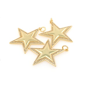 May include: Three gold-tone star-shaped charms with a clear rhinestone border. Each charm has a loop for attaching to a necklace or bracelet.