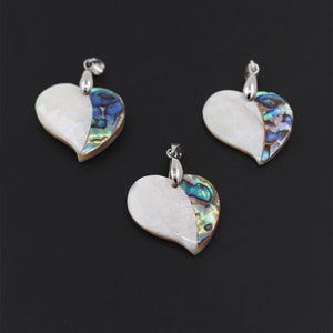 May include: Three silver heart-shaped pendants with a white mother-of-pearl front and a blue and green abalone shell back.