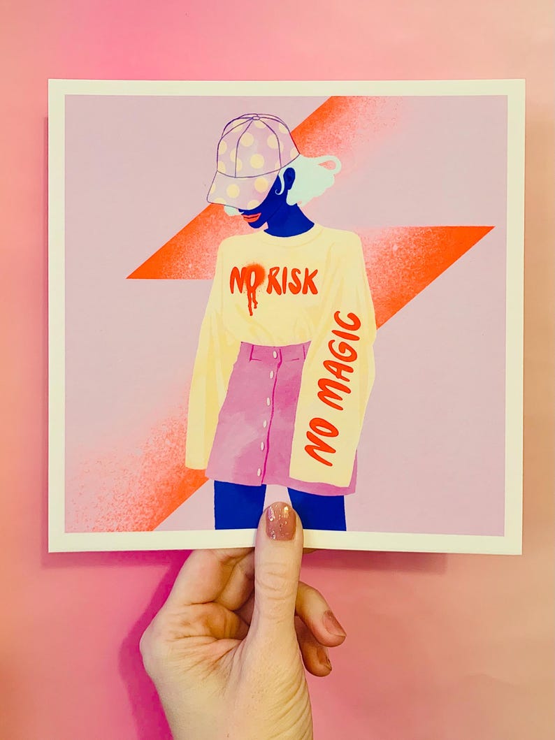 May include: A square art print featuring a stylized illustration of a figure wearing a polka-dot baseball cap, a long-sleeved cream shirt with the red text NO RISK, and a pink button-front skirt. The sleeve features the red text NO MAGIC.