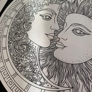 May include: A black and white line art illustration featuring a crescent moon with a human face and flowing, swirling hair, positioned next to a sun with a human face and radiating sunbeams, both enclosed within a circular decorative border.