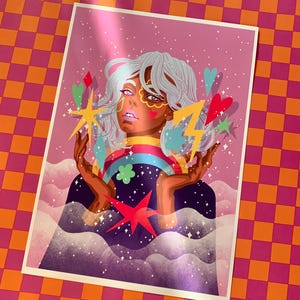 K&ouml;nnte beinhalten: Ein rechteckiger Kunstdruck mit einer stilisierten Illustration einer Person mit hellem Haar, umgeben von bunten schwebenden Elementen wie einem Regenbogen, einem gelben Blitz, Sternen, Herzen und Wolken vor einem rosafarbenen Sternenhintergrund.