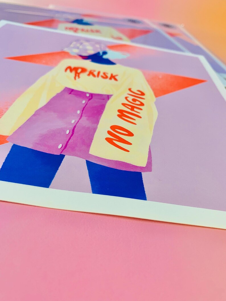 May include: A square art print featuring a stylized illustration of a figure wearing a yellow long-sleeve shirt with the red text NO RISK and NO MAGIC, paired with a purple button-down skirt and dark blue pants, set against a large orange star.