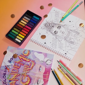 Può includere: Un libro da colorare con rilegatura a spirale con un'illustrazione in bianco e nero di una persona, una scatola rettangolare contenente ventiquattro pastelli colorati e diverse matite colorate. La copertina riporta il testo Color Me e Pandemic Child.