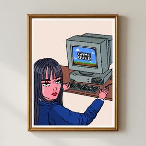 May include: A framed print featuring a pixelated computer screen displaying "GAME OVER." A person with long black hair and a blue jacket is depicted with tears, seated at a desk. The artwork has a retro video game aesthetic.