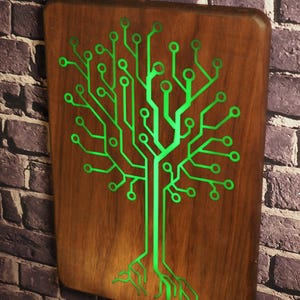 May include: A rectangular wooden wall plaque featuring a glowing green circuit board pattern shaped like a tree with branches and roots. The wood has a smooth, polished finish, and the integrated light illuminates the intricate electronic pathways.