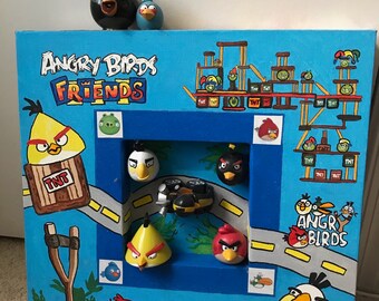 May include: A blue and green painted wooden frame with a picture of Angry Birds characters. The frame includes the words "Angry Birds Friends" and "Angry Birds".