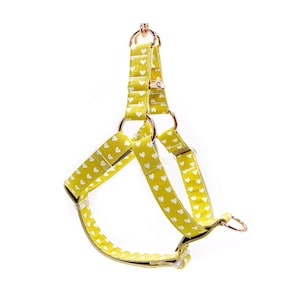May include: A yellow dog harness with white heart print and rose gold hardware.