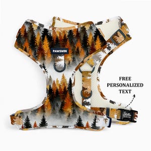 May include: A dog harness with a forest scene design in shades of brown, orange, and black. The harness has adjustable straps, metal D-rings, and a buckle closure. The text "PAWSWIN" is visible on the front. The text "FREE PERSONALIZED TEXT" is also visible.