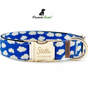 Könnte beinhalten: Blauer Hundehalsband mit weißen Wolken und goldenen Beschlägen. Das Halsband hat ein personalisiertes Namensschild mit der Aufschrift "Stella" und einer Telefonnummer. Das Halsband wird von Pawswin Classic hergestellt.