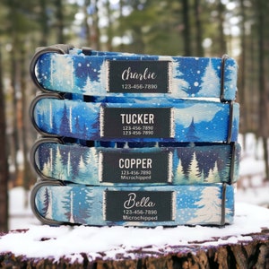 Könnte beinhalten: Vier Hundehalsbänder mit einem Winterwald-Druck. Die Halsbänder sind übereinander gestapelt. Jedes Halsband hat ein schwarzes Schild mit einem Namen und einer Telefonnummer. Die Namen sind Charlie, Tucker, Copper und Bella. Die Schilder weisen auch auf "Mikrochip" hin.