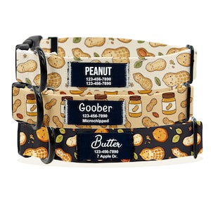 以下が含まれることがあります： 黒い金具が付いた3つの犬用首輪。一番上の首輪はベージュで、ピーナッツの模様と「Peanut」という名前が入っています。真ん中の首輪はタン色で、ピーナッツバターの瓶と「Goober」という名前が入っています。一番下の首輪は黒で、ピーナッツと「Butter」という名前が入っています。