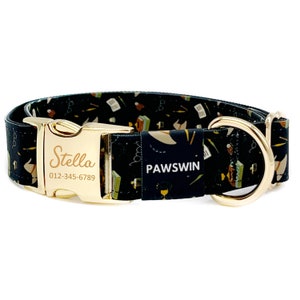 Puede incluir: Un collar de perro negro con una hebilla dorada y un anillo en D dorado. El collar tiene un patrón en blanco y negro con una variedad de objetos, incluyendo libros, gafas y lápices. La hebilla tiene el nombre "Stella" y un número de teléfono grabado en ella. El collar también tiene la palabra "PAWSWIN" impresa en él.